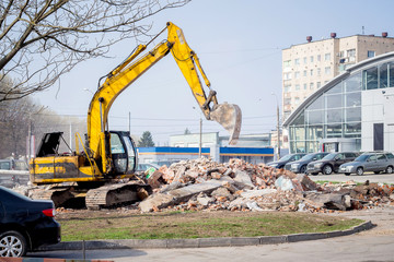 Crawler excavator is working on  construction site. The excavator unloads construction debris_