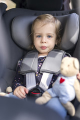 cute happy small girl in car seat in the car