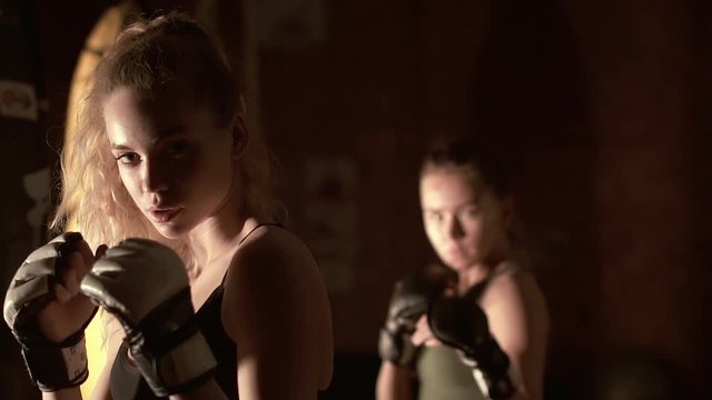 Two girls kickboxer warm up before the fight. Slow motion.