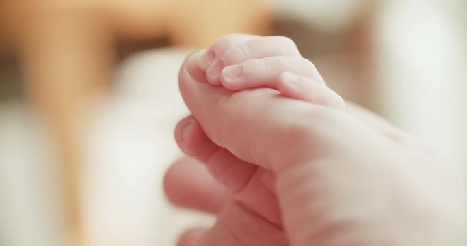 4k.Mother and newborn baby in maternity home. Hand in hand, slow motion. Parenthood. Motherhood.