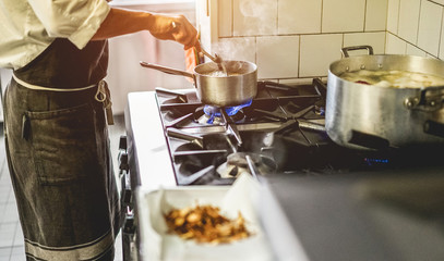 Male chef cooking in restaurant kitchen - Cook at work during dinner service
