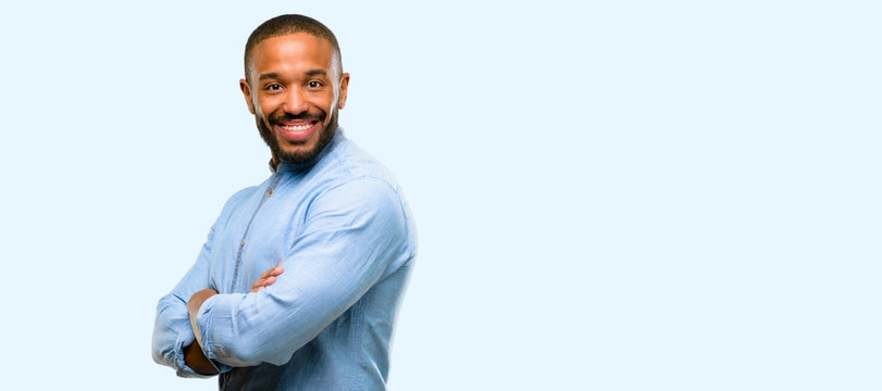 African american man with beard with crossed arms confident and happy with a big natural smile laughing isolated over blue background