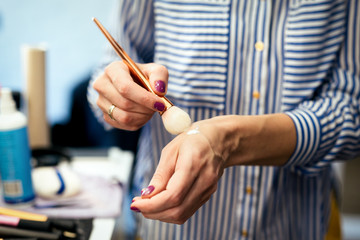 Female makeup artist with cosmetics at work close-up