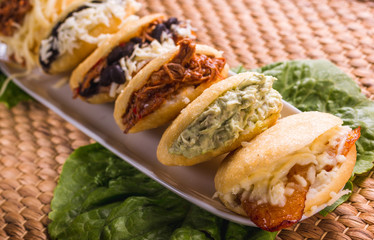 Different types of arepas, meat, black beans, cheese, fried plantain, typical South American food