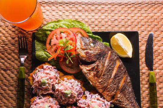 fried fish with fried plantain and salad, beach food in Venezuela