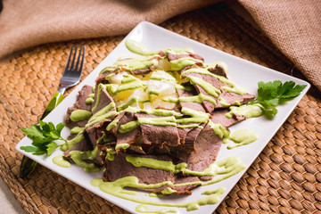 grilled sliced steak and patatoes on white plate, top view