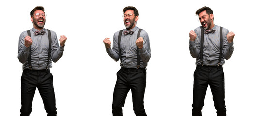 Middle age man, with beard and bow tie happy and excited expressing winning gesture. Successful and celebrating victory, triumphant