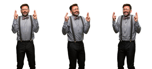 Middle age man, with beard and bow tie with crossed fingers asking for good luck