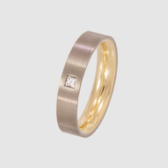 Damenring ist zweifarbig aus Weissgold und Gelbgold zusammengesetzt. Die Oberfläche ist mattiert. Es ist ein Diamant im Facettenschliff eingesetzt