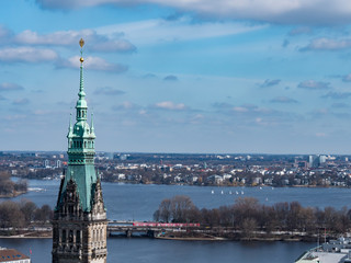 Beautiful day at the Alster lake with sailing boats and spire of the townhall in front, Hamburg,Germany.