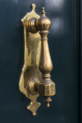 Door knocker close-up on a wooden wall 