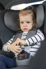 cute small girl in car seat in the car