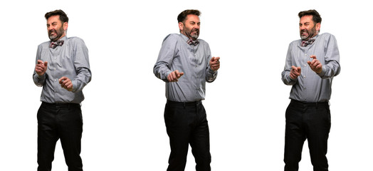 Middle age man, with beard and bow tie disgusted and angry, keeping hands in stop gesture, as a defense, shouting