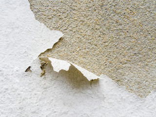 The paint on the old cement wall is peeling.