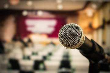 Microphone on abstract blurred of speech in seminar room or speaking conference hall light, Speaker...