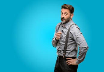 Middle age man, with beard and bow tie nervous and scared biting lips looking camera with impatient...