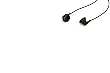 small black tangled headphones lying on white background