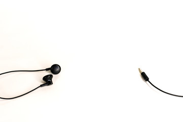 small black tangled headphones lying on white background