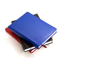 three notebook are stacked on each other on white background