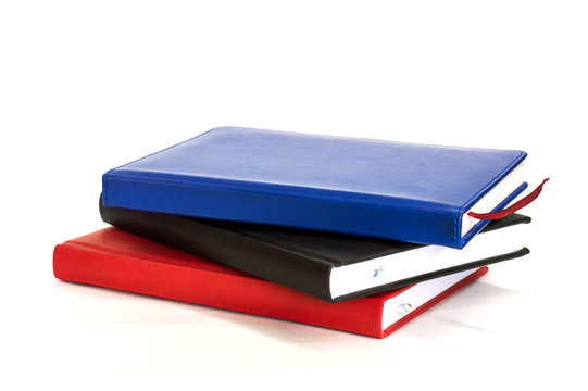 three notebook are stacked on each other on white background