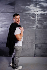 Studio portrait of man in casual suit against steel background.