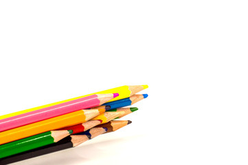 colored pencils lying on white background