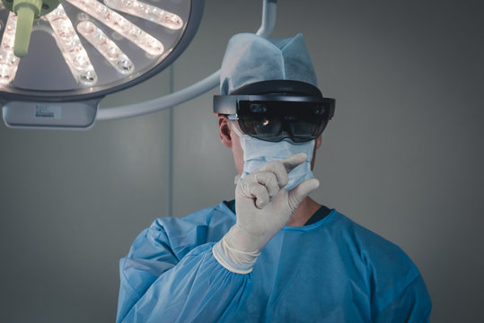 Surgeon using augmented reality holographic hololens glasses while operating in modern operation theater