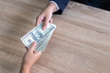 close up hand of business giving or paying money  US dollar bill