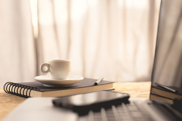 Coffee cup and laptop on coffee desk