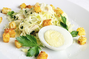 egg, parsley leafs, and fried with spices croutons decorating cabbage chicken mayo salad  