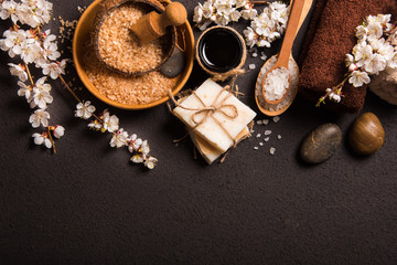 Spring Spa concept: sea salt, flowering cherry branches, towel, soap. Top view.