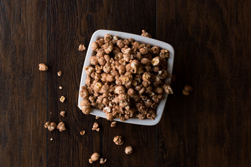 Chocolate Popcorn on dark Wooden Surface.