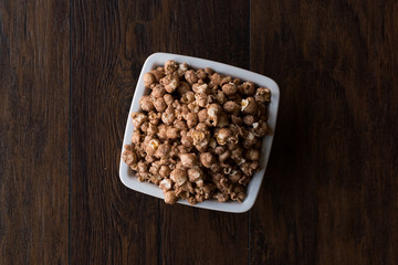 Chocolate Popcorn on dark Wooden Surface.