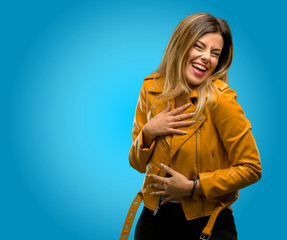 Beautiful young woman confident and happy with a big natural smile laughing, blue background