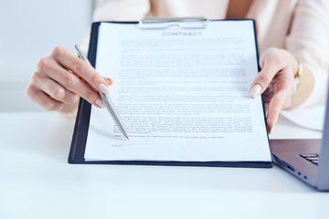 Young businesswoman giving contract for you to sign. Just Hands over the table.