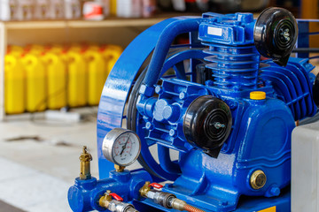 Air pump and pressure gauge in motorcycle repair shop.