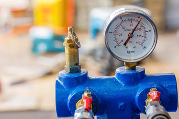 Air pump and pressure gauge in motorcycle repair shop.