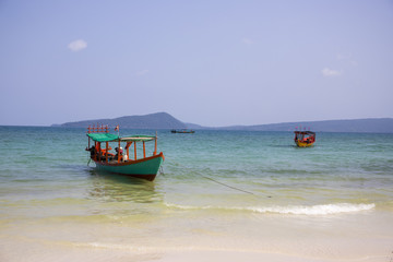 Cambodian traditional fishing boat near Koh Rohn island seashore. Green and red wooden boat.