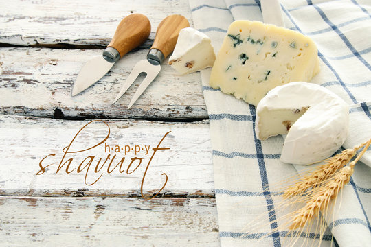 image of dairy products over white wooden planks background. Symbols of jewish holiday - Shavuot.