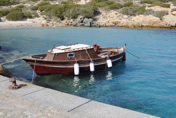 Obraz premium Barca amarrada en una cala de la ISla de CErdeña, Costa Esmeralda, Italia