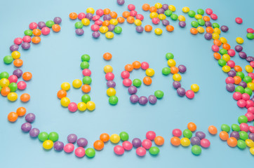candy caramel lined word diet, on blue background, closeup