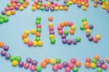 candy caramel lined word diet, on blue background, closeup