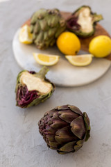 Obraz premium Healthy lifestyle concept. Artichokes and lemons on concrete tab