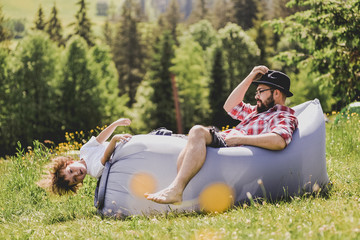 Father and son resting on an air sofa in the mountains. lamzac. Travel.
