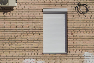 closed window shutters on a brick wall background