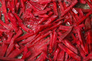 Fototapeta premium texture, finely chopped beets fried in a skillet in vegetable oil closeup, roasting.