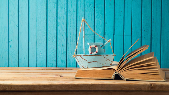 Boat and book on wooden table
