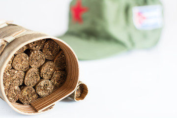 Cuban cigars rolled in banana leaf and military cap on the background