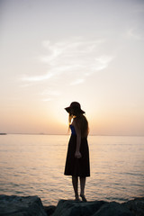 Fototapeta premium Beautiful girl on a sunset background on a sandy beach