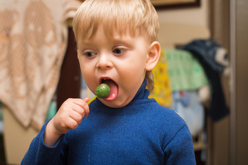 blonde boy licking a Lollipop